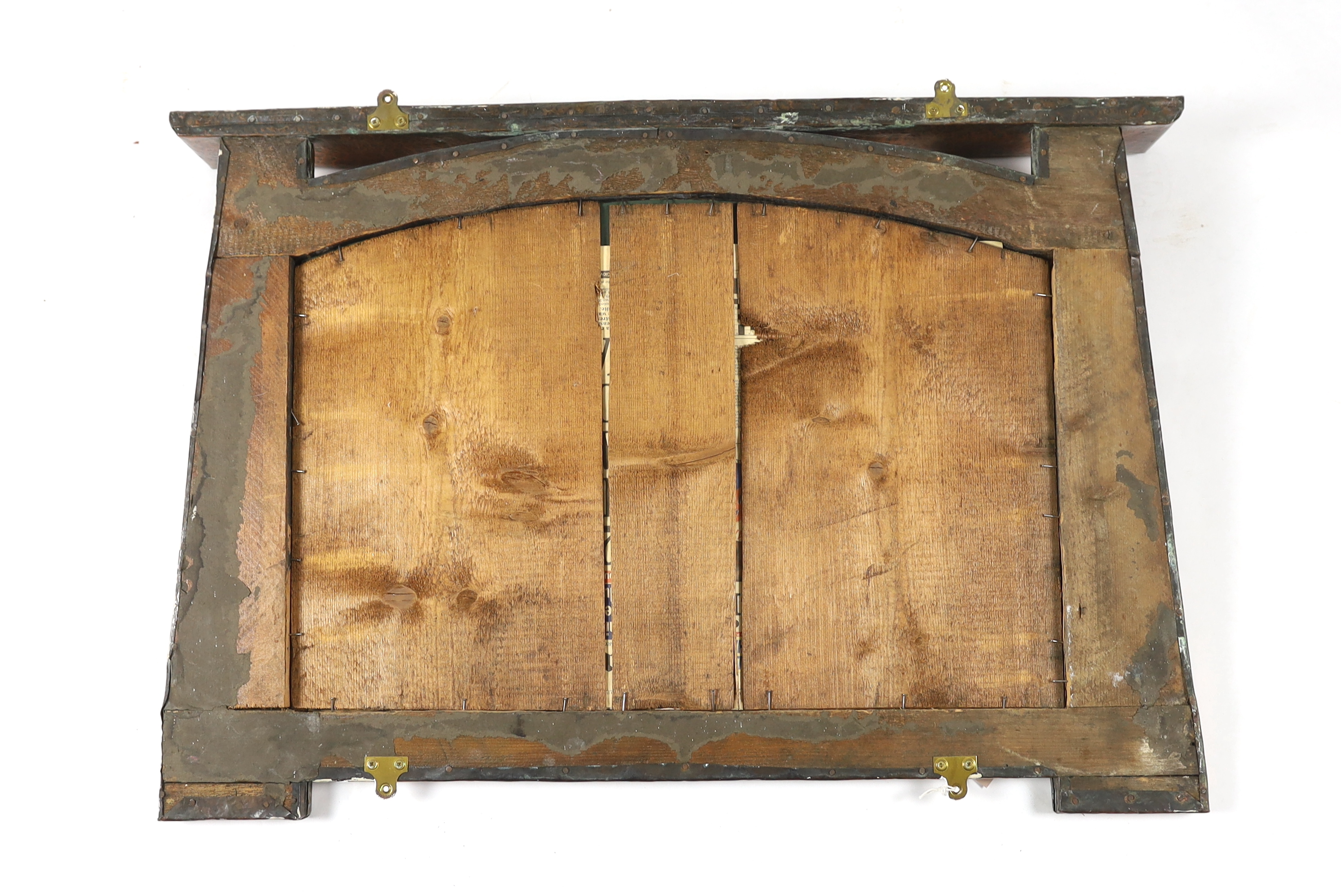 In the manner of Archibald Knox, a Scottish Arts & Crafts planished copper overmantel, 92cm wide, 65cm high